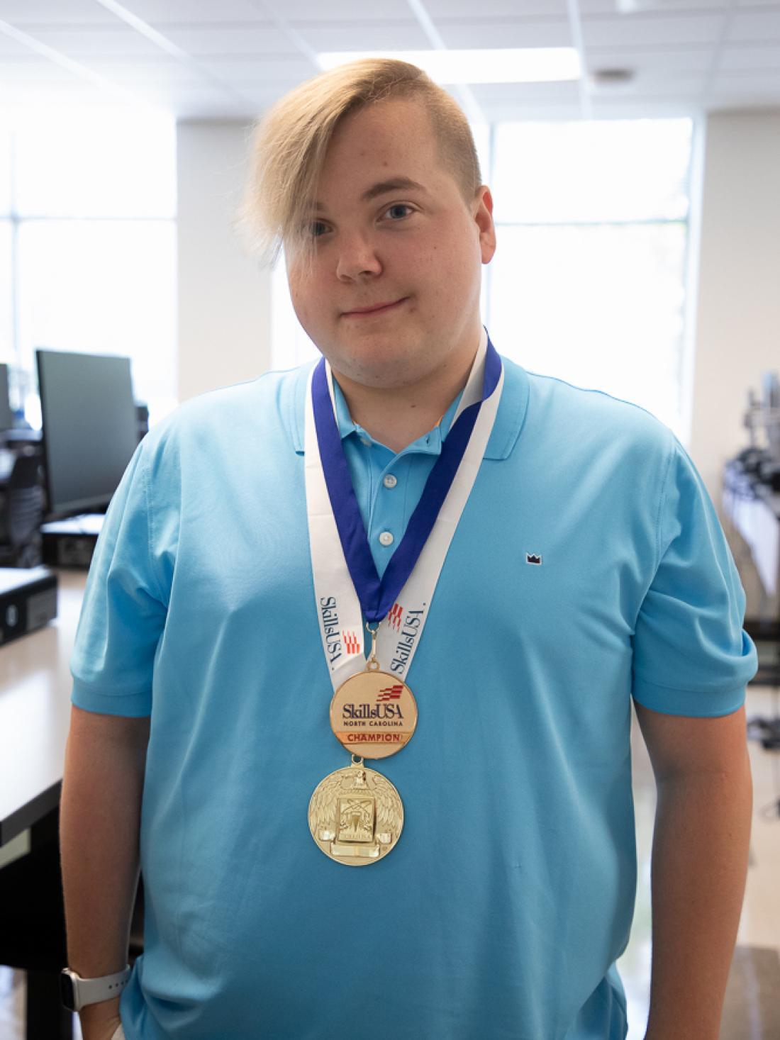 Craven CC Information Technology student Benton Melville poses with his two SkillsUSA gold medals for the 2023 state and national competitions.